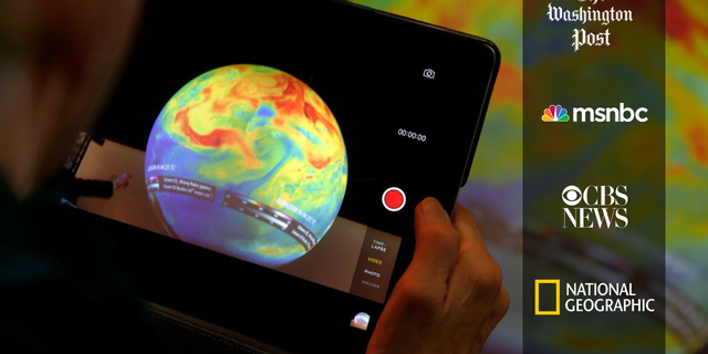 A woman takes a picture of a globe at the COP21, the United Nations Climate Change Conference Monday, Dec. 7, 2015 in Le Bourget, north of Paris. The Paris conference is the 21st time world governments are meeting to seek a joint solution to climate change. The talks are focused on reducing emissions of carbon dioxide and other greenhouse gases, primarily by shifting from oil, coal and gas to cleaner sources of energy.