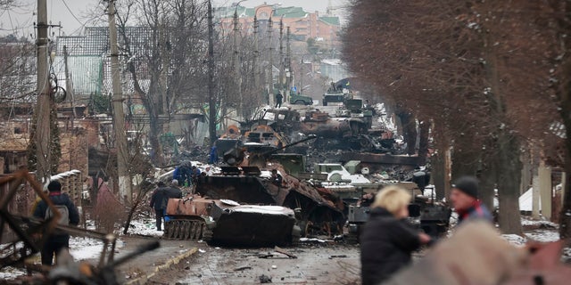 People look at the gutted remains of Russian military vehicles on a road in the town of Bucha, close to the capital Kyiv, Ukraine on March 1. Russian forces have struggled to make progress in Ukraine amid heavy fighting and fierce resistance. 