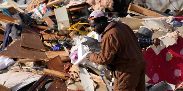 A resident looks through the piles of debris, insulation, and home furnishings to see if anything is salvageable at a tornado demolished mobile home park in Rolling Fork, Miss. March 25, 2023.  Emergency officials in Mississippi say several people have been killed by tornadoes that tore through the state on Friday night, destroying buildings and knocking out power as severe weather produced hail the size of golf balls moved through several southern states. 
