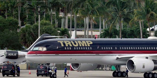 People work around the private plane of former president Donald Trump as it sits parked on the tarmac at Palm Beach International Airport, Monday, April 3, 2023, in West Palm Beach, Fla. Trump was expected to travel later in the day to New York City for his arraignment after being indicted by a Manhattan grand jury.