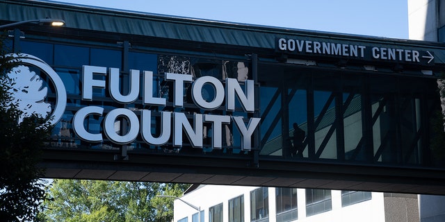 People walk across the bridge outside The Fulton County Court House on Sept. 29, 2022 in Atlanta, Ga.