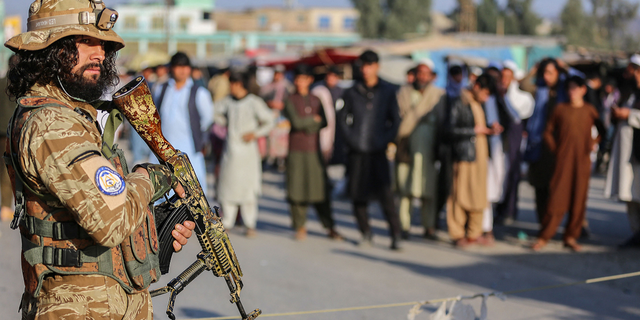 Taliban member stands guard near Afghanistan-Pakistan border crossing