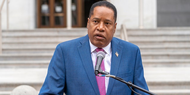 Larry Elder at lectern speaking outdoors