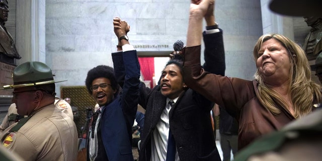 Rep. Justin Pearson, Rep. Justin Jones, Rep. Gloria Johnson People hold their hands up as they exit the House Chamber doors at Tennessee State Capitol Building in Nashville, Tenn., Monday, April 3, 2023.