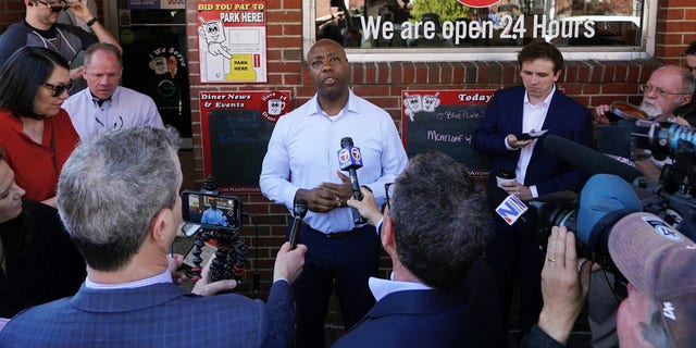 Sen. Tim Scott of South Carolina takes questions from reporters outside of the Red Arrow Diner, on  April 13, 2023 in Manchester, New Hampshire