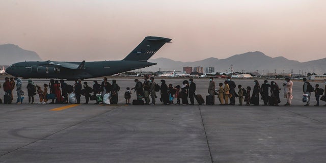 In this image provided by the U.S. Marine Corps, evacuees wait to board a Boeing C-17 Globemaster III, at Hamid Karzai International Airport, Kabul, Afghanistan, on Monday. (AP/Sgt. Isaiah Campbell/U.S. Marine Corps)