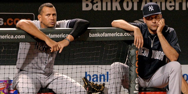 Alex Rodriguez #13 (L) and Derek Jeter #2 of the New York Yankees look on against the Baltimore Orioles in the ninth inning at Oriole Park at Camden Yards on September 11, 2013 in Baltimore, Maryland.