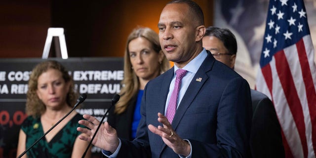 Hakeem Jeffries speaks at a podium with other members of House Democratic leadership standing beside him