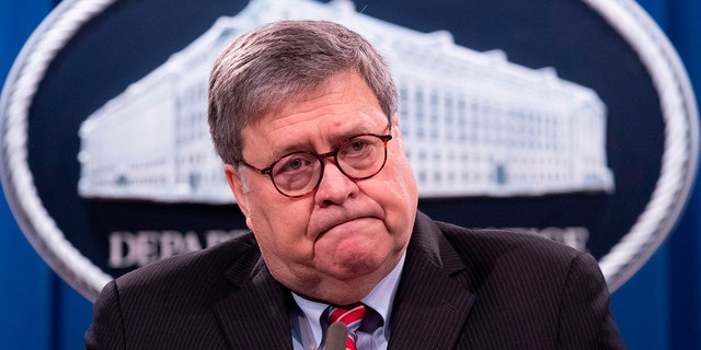 William Barr with DOJ press briefing room sign behind him