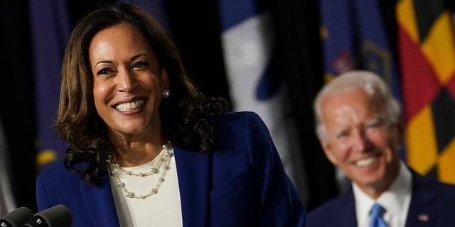 Kamala Harris smiles as Joe Biden looks on