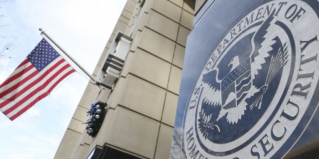 homeland security logo on building, US flag at left