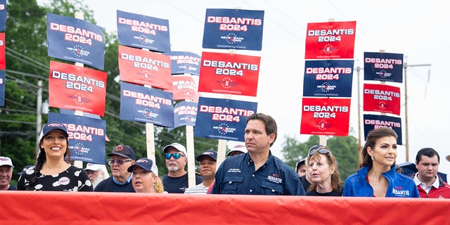 DeSantis, his wife and supporters with campaign signs