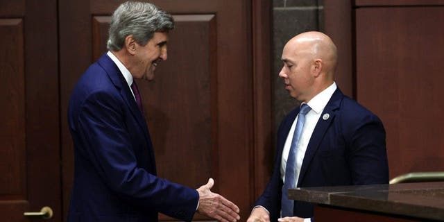 John Kerry (L) and Rep. Brian Mast (R-FL) (R)