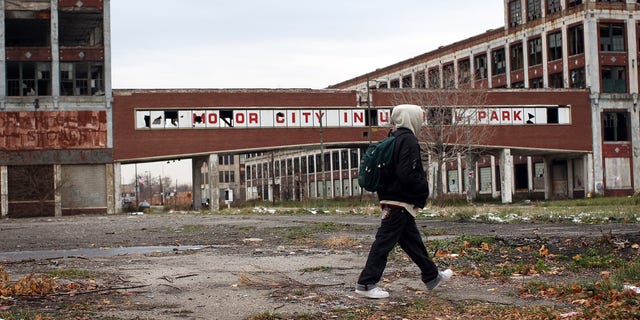 A person walks past the remains of the Packard Motor Car Company, which ceased production in the late 1950s, on Nov. 19, 2008 in Detroit, Michigan. 