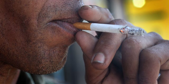 Gedwyn Power smokes a menthol cigarette in front of a Quick Stop store on March 30, 2010 in Miami, Florida. 