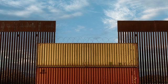 Border wall in Arizona covered with shipping crate