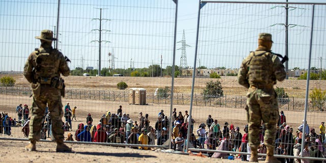 Border Patrol agents stand in front of gate