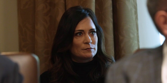 White House Press Secretary and Communications Director Stephanie Grisham listens