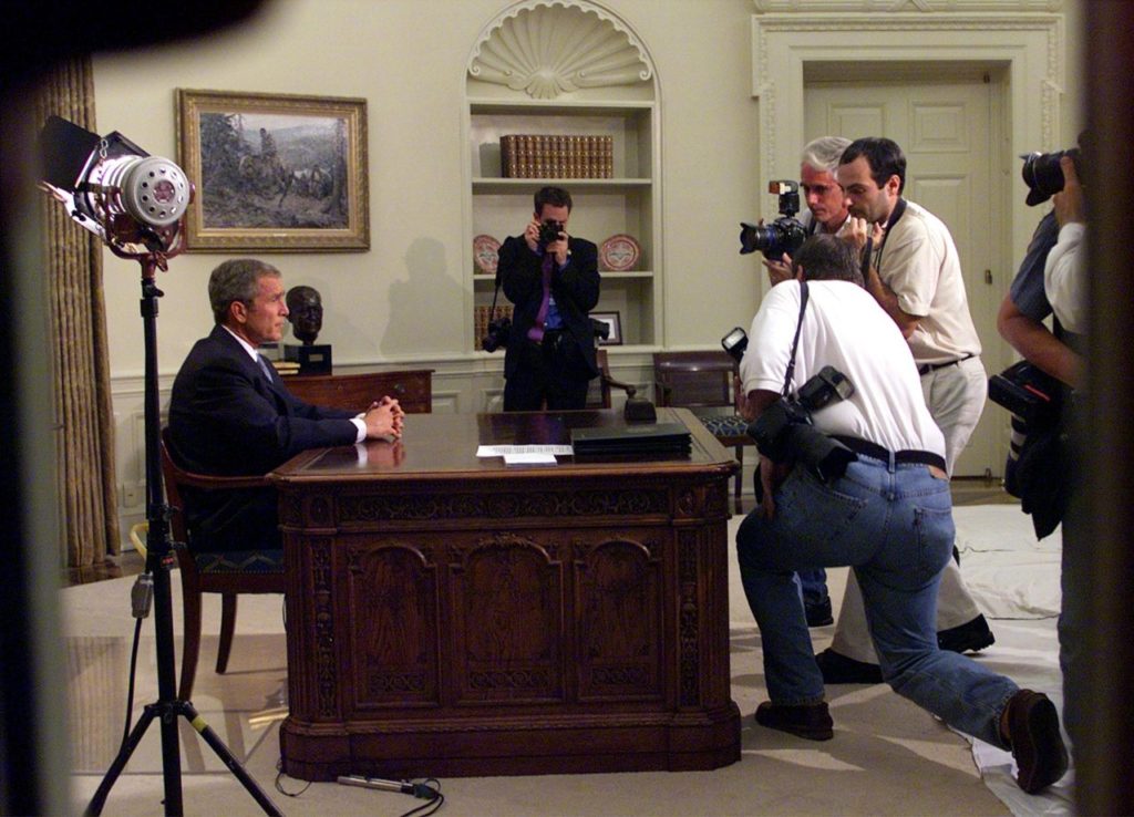 President Bush is seen through the windows of the Oval Office of the White House in Washington, Tuesday, Sept. 11, 2001, as he addresses the nation about terrorist attacks at the World Trade Center and the Pentagon. (AP Photo/Doug Mills)