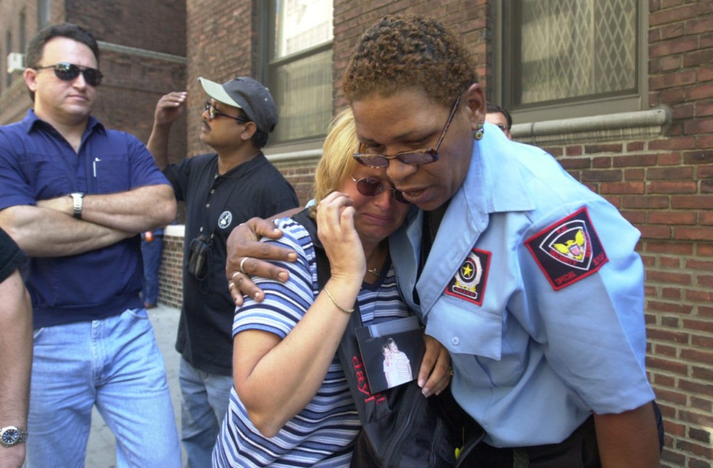 In this September 13, 2001 photograph, a woman is comforted as she holds a picture of a missing loved one who was last seen at the World Trade Center when it was attacked on September 11, 2001.(AP Photo/Kathy Willens)