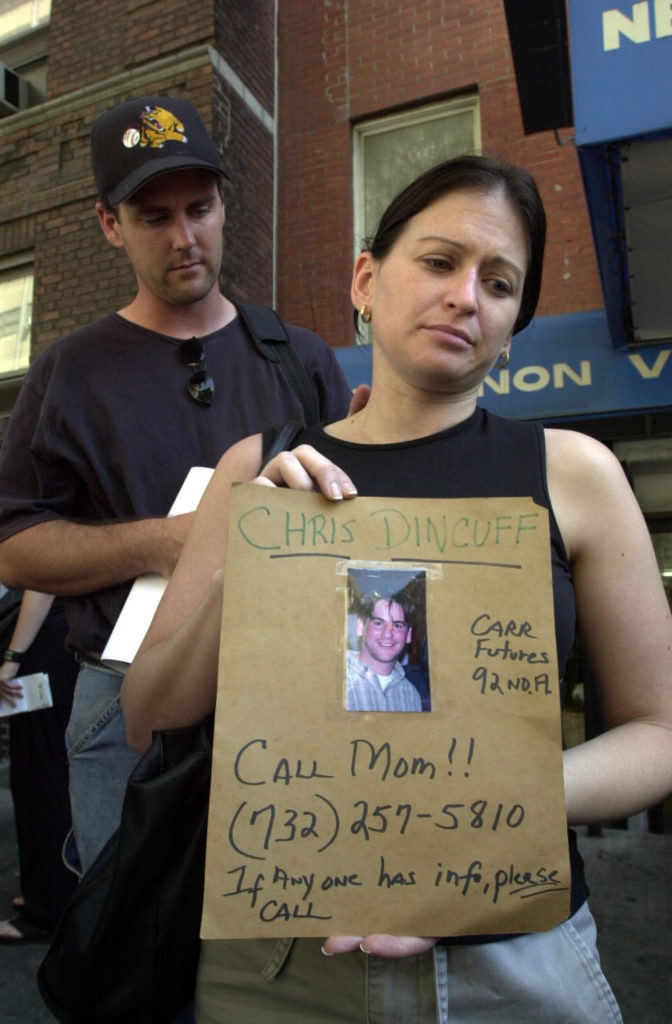 In this September 13, 2001 photograph, a woman poses with a picture of a missing loved one who was last seen at the World Trade Center when it was attacked on September 11, 2001.(AP Photo/Kathy Willens)