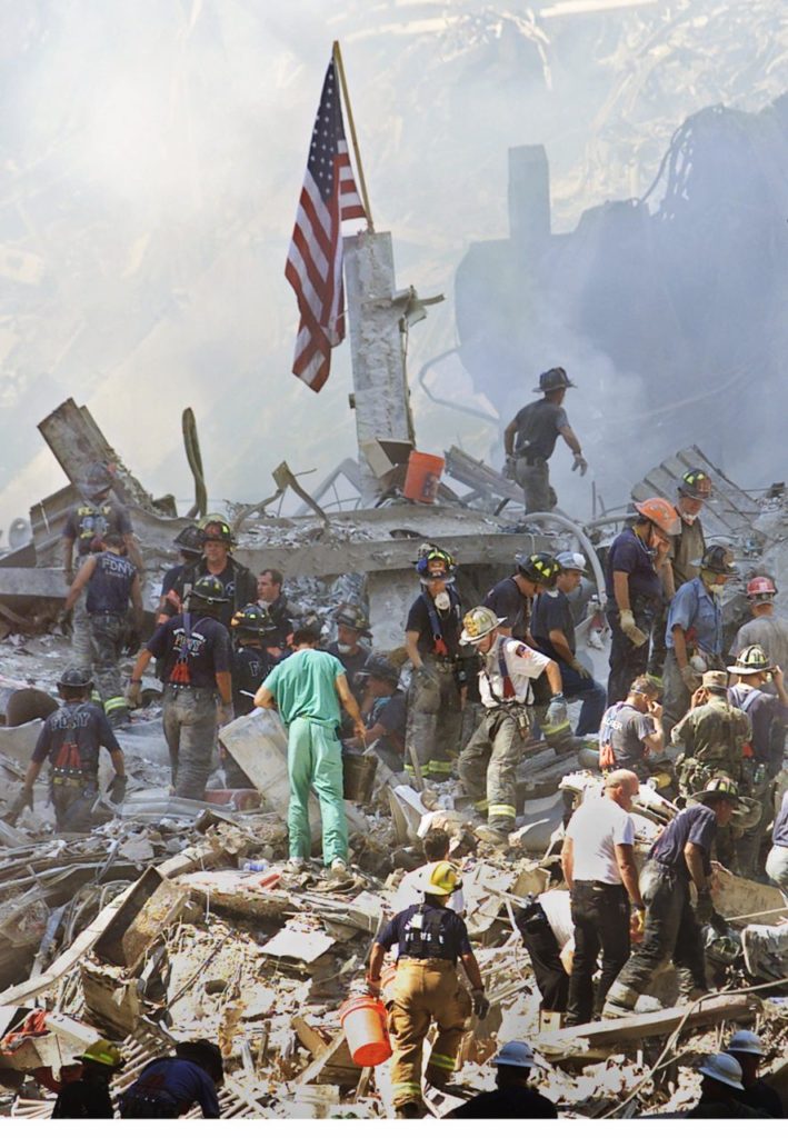 An American flag is posted in the rubble of the World Trade Center Thursday, Sept. 13, 2001, in New York. The search for survivors and the recovery of the victims continues since Tuesday's terrorist attack. (AP Photo/Beth A. Keiser)