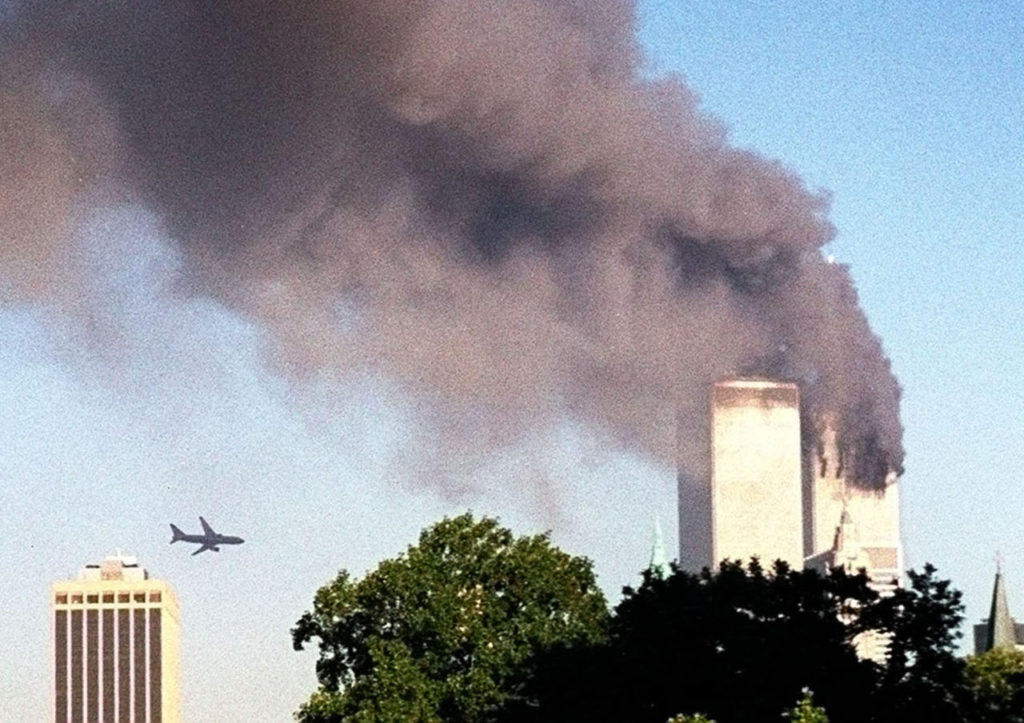 A plane approaches New York's World Trade Center moments before it struck the tower at left, as seen from downtown Brooklyn, Tuesday, Sept. 11, 2001. In an unprecedented show of terrorist horror, the 110 story towers collapsed in a shower of rubble and dust after 2 hijacked airliners carrying scores of passengers slammed into them. (AP Photo/ William Kratzke)
