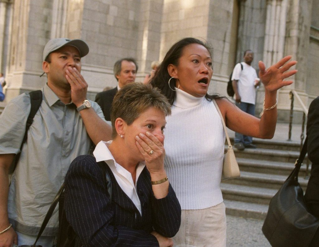 People in front of New York's St. Patrick's Cathedral react with horror as they look down Fifth Ave towards the World Trade Center towers after planes crashed into their upper floors in this Sept. 11, 2001, file photo. Explosions and fires collapsed the 110-story buildings. This year will mark the fifth anniversary of the attacks. (AP Photo/Marty Lederhandler/FILE)