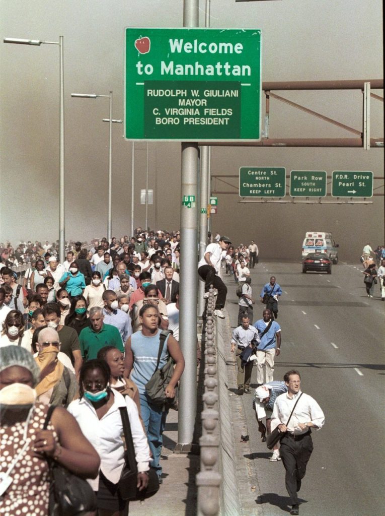 People flee lower Manhattan across the Brooklyn Bridge in New York, Tuesday, Sept. 11, 2001, following a terrorist attack on the World Trade Center. (AP Photo/Daniel Shanken) MANDATORY CREDIT