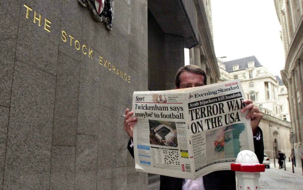 LONDON, UNITED KINGDOM: A trader of the stock exchange reads the evening paper with" Terror war on USA" on the front page 11 September 2001 outside the London stock exchange, following the terrorist attacks at the World Trade Center and the Pentagon in USA earlier today. (Photo credit should read NICOLAS ASFOURI/AFP/Getty Images)
