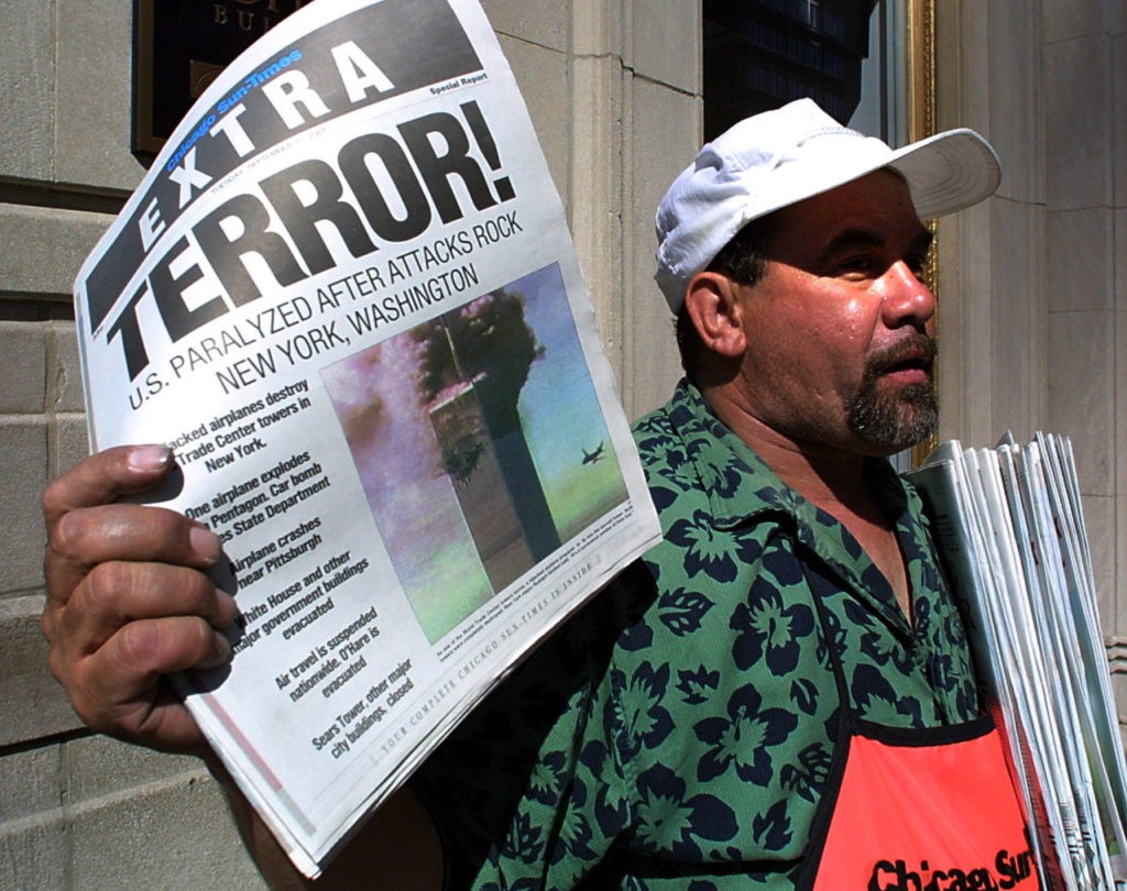 Newspaper vendor Carlos Mercado sells the "Extra" editon of the Chicago Sun-Times printed 11 September, 2001, after the terrorist attacks on the United States. Two hijacked airplanes crashed into the World Trade Center twin towers in New York while one hijacked plane later crashed at the Pentagon in Washington, DC, with another plane crashing 80 miles outside of Pittsburgh, Pennsylvania. AFP PHOTO/Scott OLSON (Photo credit should read SCOTT OLSON/AFP/Getty Images)