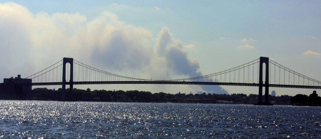Smoke rises in the distance before the Long Island and the Throgs Neck Bridge 11 September 2001 between the Bronx and Queens, NY, following the destruction of the the twin towers of the World Trade Center. An apparent terrorist attack leveled the two buildings. AFP PHOTO/Matt CAMPBELL (Photo credit should read MATT CAMPBELL/AFP/Getty Images)