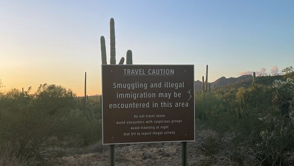 A sign warns of the dangers of encountering human smugglers and migrants crossing from Mexico and marching through the desert. (Randy Clark/Breitbart Texas)