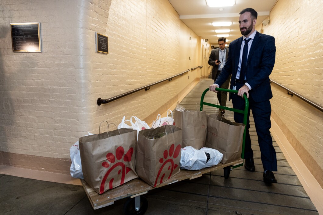 A congressional staffer wheels a trolly carrying Chick-fil-A food ahead of a House Republican conference meeting in the basement of the Capitol Building on Thursday, Oct. 12, 2023.