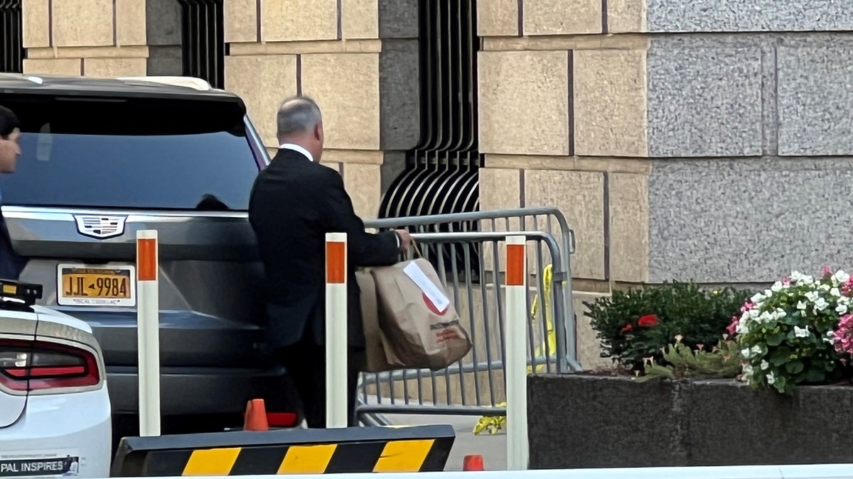 Staffers carry bags of McDonald's into Manhattan court building