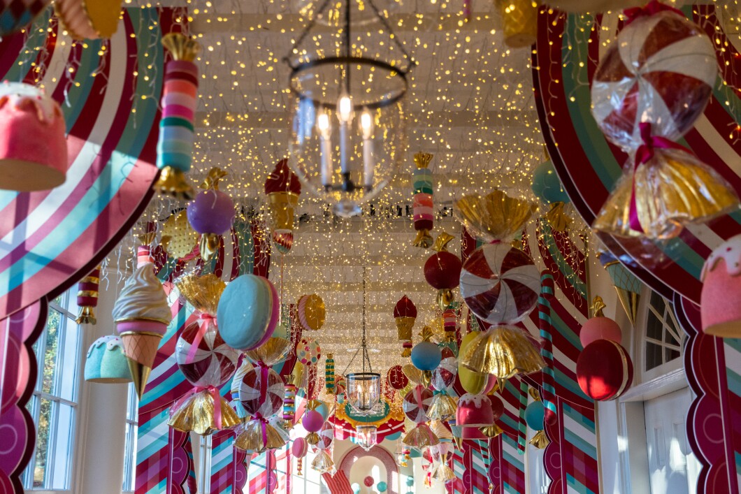 Candy-themed ornaments hang from the ceiling of the hallway between the East Wing and the residence of the White House on Nov. 27, 2023. The theme for this year's White House decorations is "Magic, Wonder and Joy," and is designed to capture the "delight and imagination of childhood."