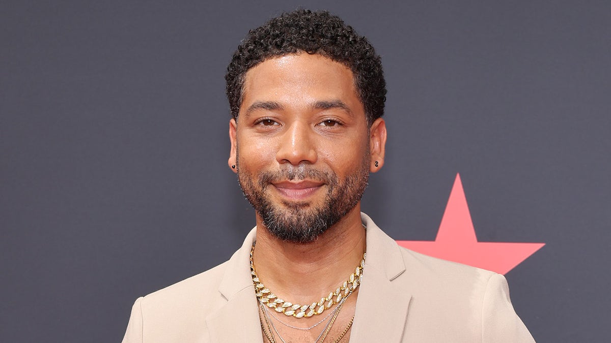 Jussie Smollett wears beige blazer with gold chains at BET awards