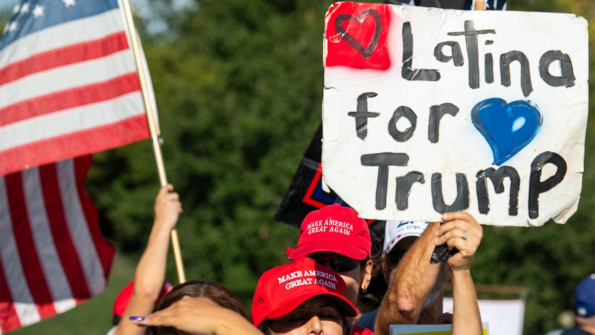 Woman holds up "Latina for Trump" sign.