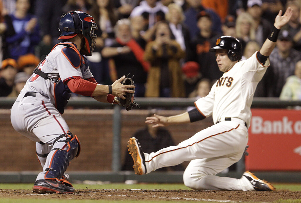 San Francisco Giants' Buster Posey, right, slides to score in front of Washington Nationals catcher Jesus Flores in the eighth inning of a baseball game Tuesday, Aug. 14, 2012, in San Francisco. Posey scored on a single by Giants' Brandon Belt. (AP Photo/Ben Margot)