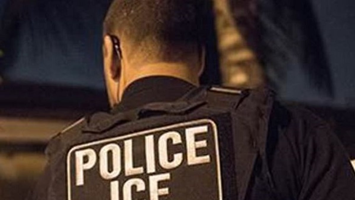 ICE officer seen from back with jacket reading "POLICE ICE"