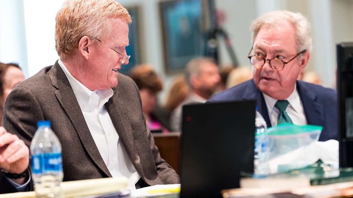 Two men speak inside a courtroom.