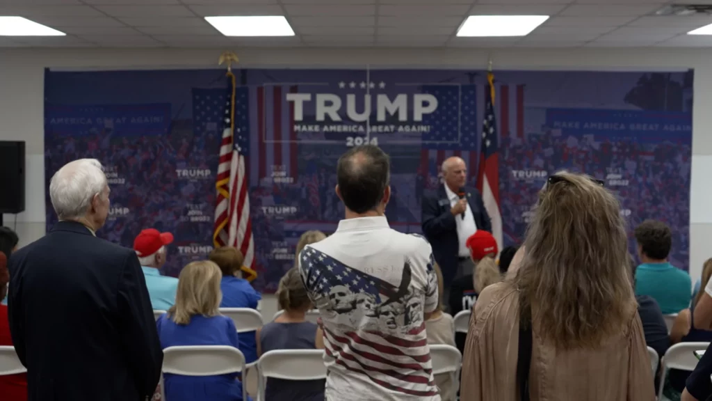 People attending standing in a crowd listening to a speech at the new Trump campaign field office in Atlanta