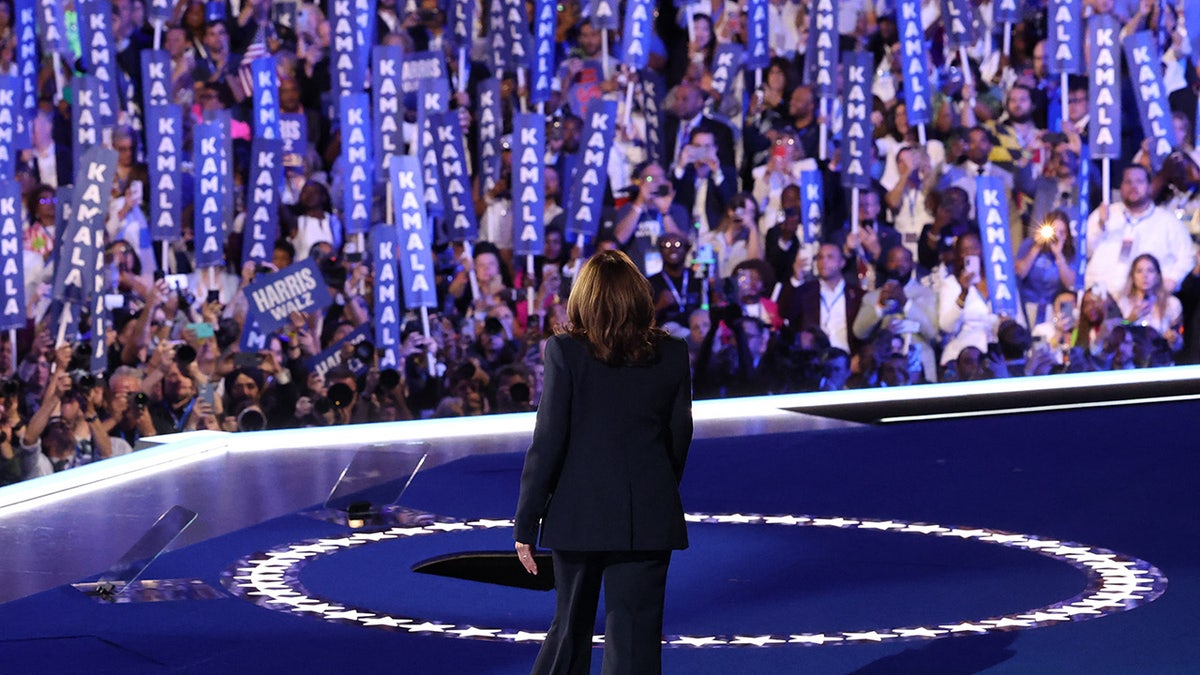 Kamala Harris taking DNC stage, seen from behind