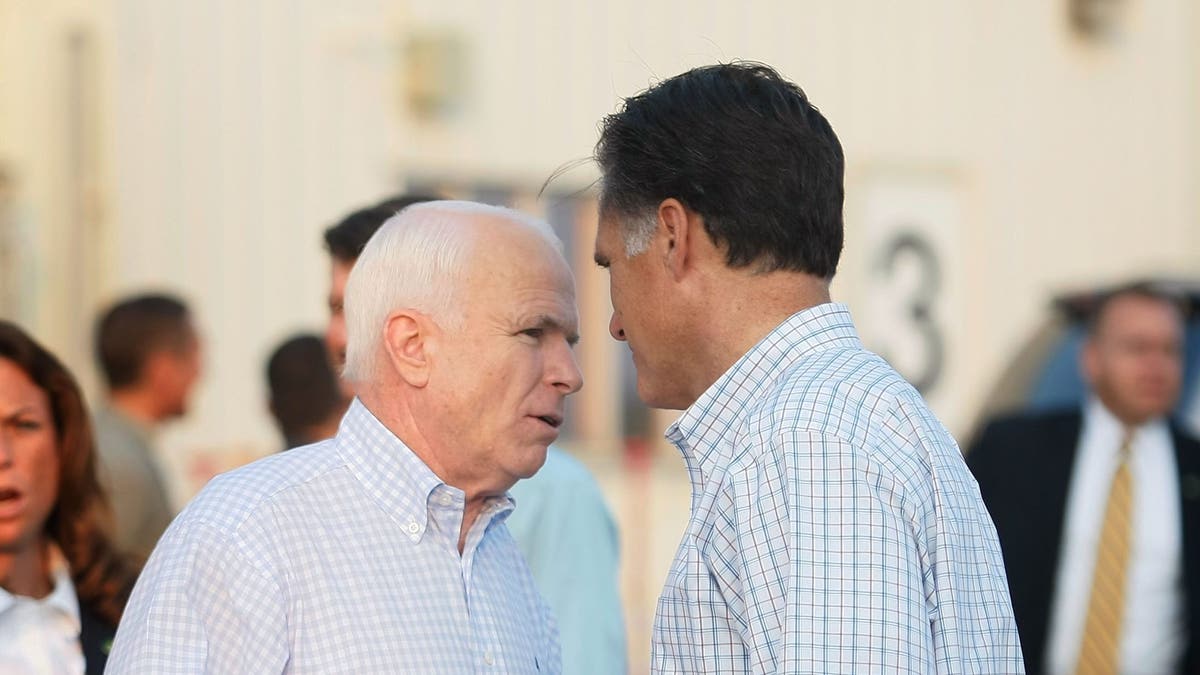 John McCain, left, and Mitt Romney talk at a campaign rally in 2008.