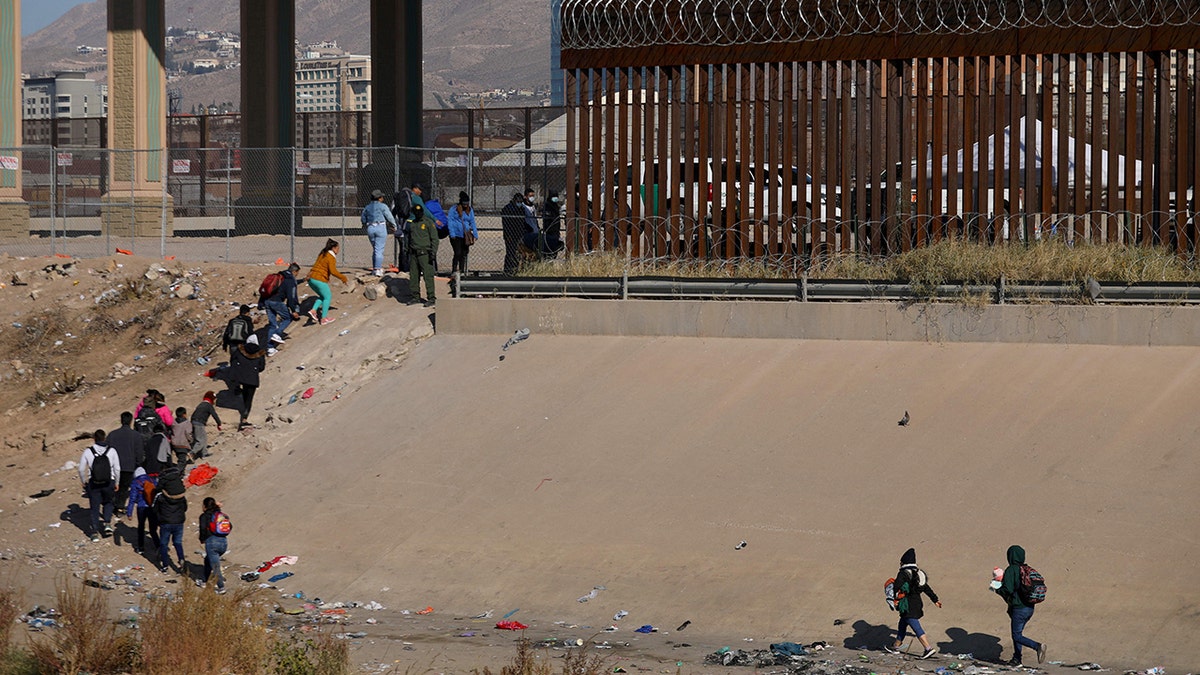 Migrants in line at border wall