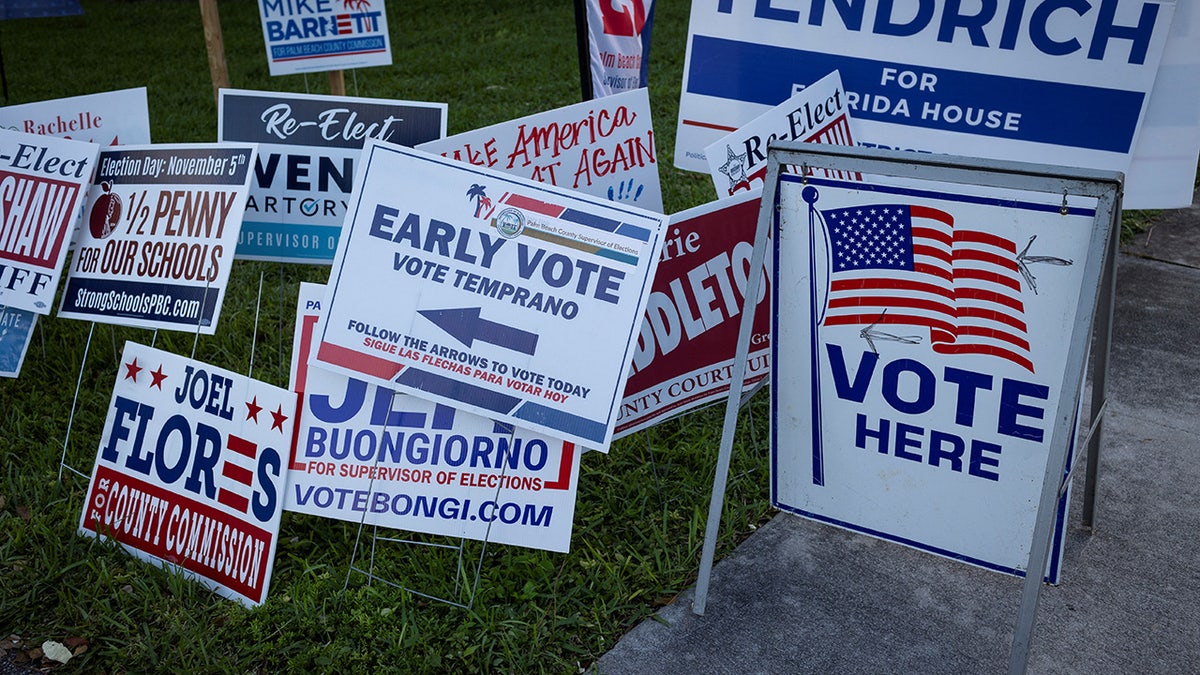 Signs are seen outside a polling station at Palm Beach County Library during early voting