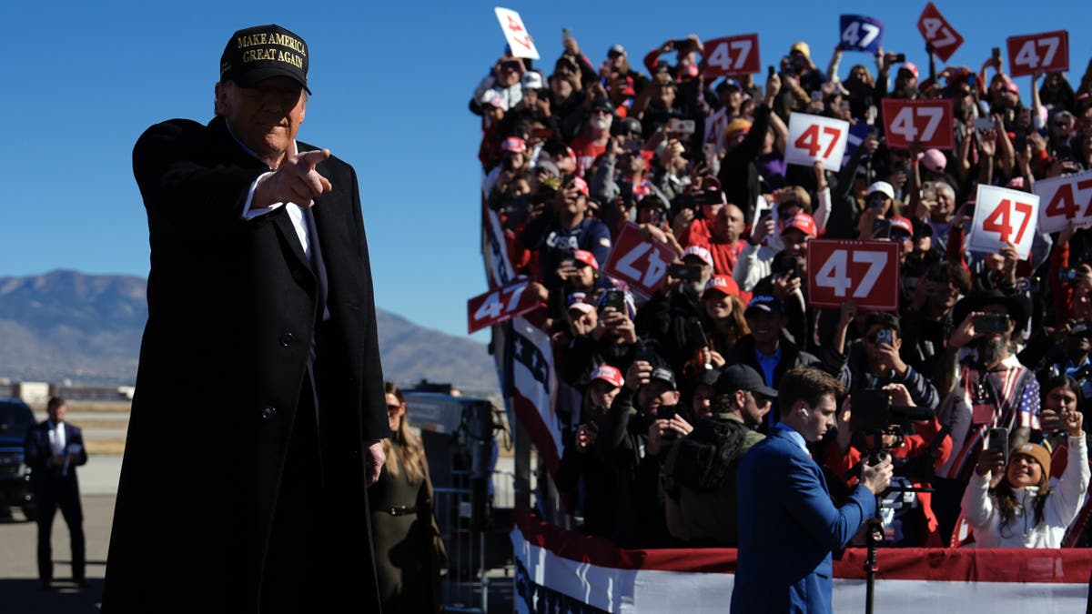 Donald Trump pointing, rally crowd behind him on the right