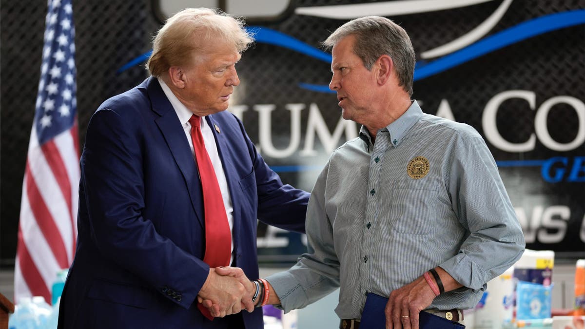 Republican presidential nominee former President Trump shakes hands with Georgia Gov. Brian Kemp after speaking at a temporary relief shelter as he visits areas impacted by Hurricane Helene, Oct. 4, 2024, in Evans, Ga.