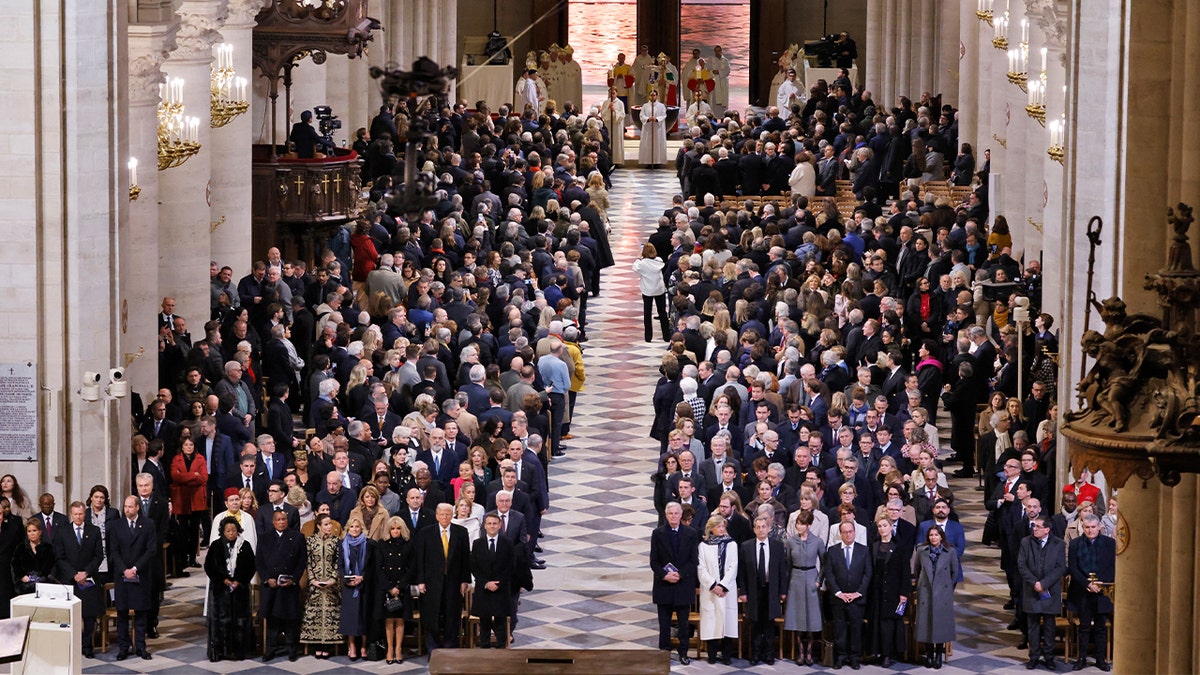 Guests stand as the doors to Notre Dame Cathedral open during a ceremony to mark the re-opening of the landmark cathedral, in central Paris, on December 7, 2024. 