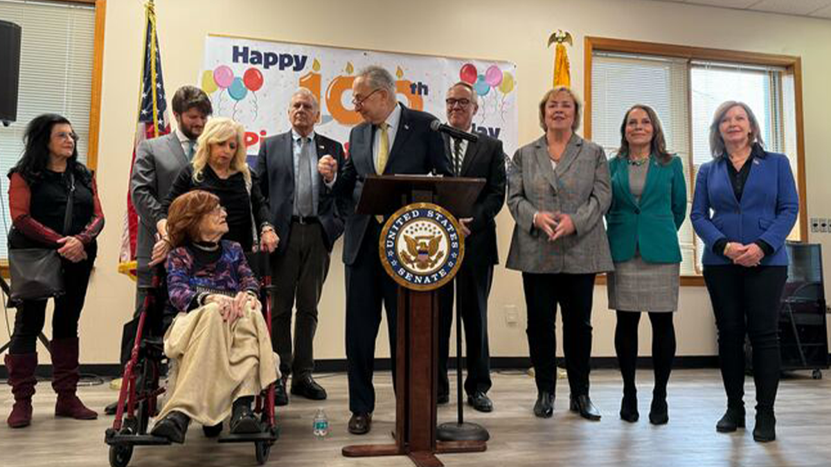 Schumer behind lectern at event honoring Holocaust survivor